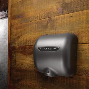 Graphite Textured Painted Excel XLERATOR hand dryer against rustic wood.