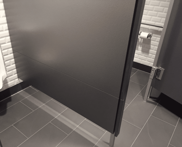 This solid plastic toilet partition, from Partition Plus, uses stacked panels to achieve extended depth (for maneuverability) and extended panel height (for privacy). Rendering of solid plastic bathroom partition using stacked panels.