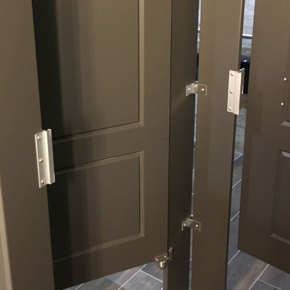 Photograph of toilet partitions, featuring hardware.