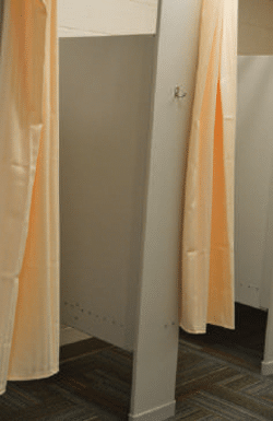 Dressing compartment with curtains in carpeted area. Photo of gray dressing compartment with curtains.