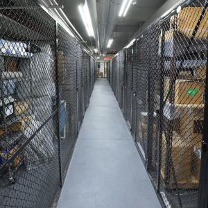 Photograph of a corridor lined with BeastWire mesh lockers in a utility area.