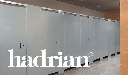 Beige toilet partitions with Hadrian logo