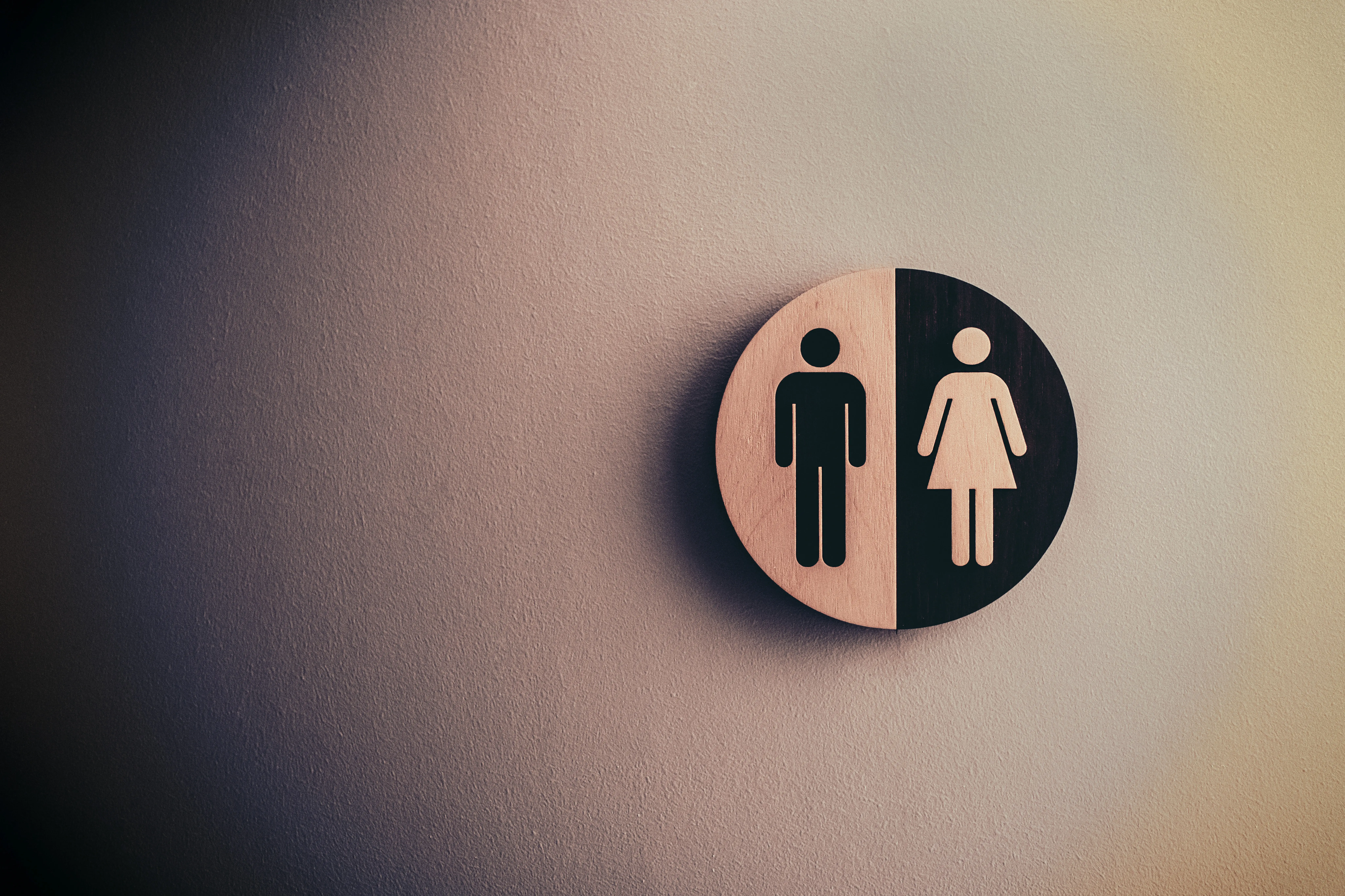 photo of a bathroom sign with a male and female figure on a wall