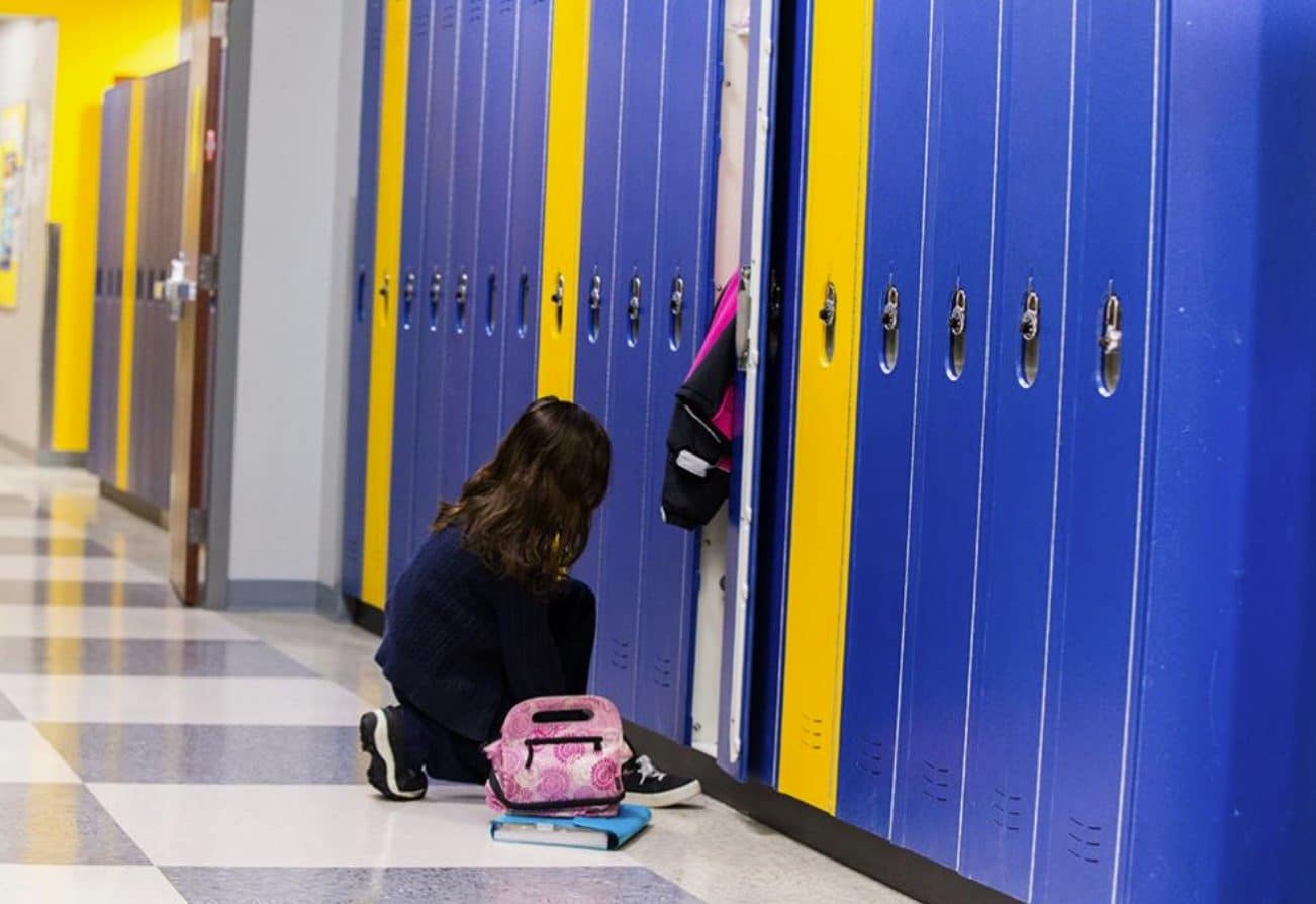 Girl knelt in front of Scranton's HDPE solid plastic Duralife lockers