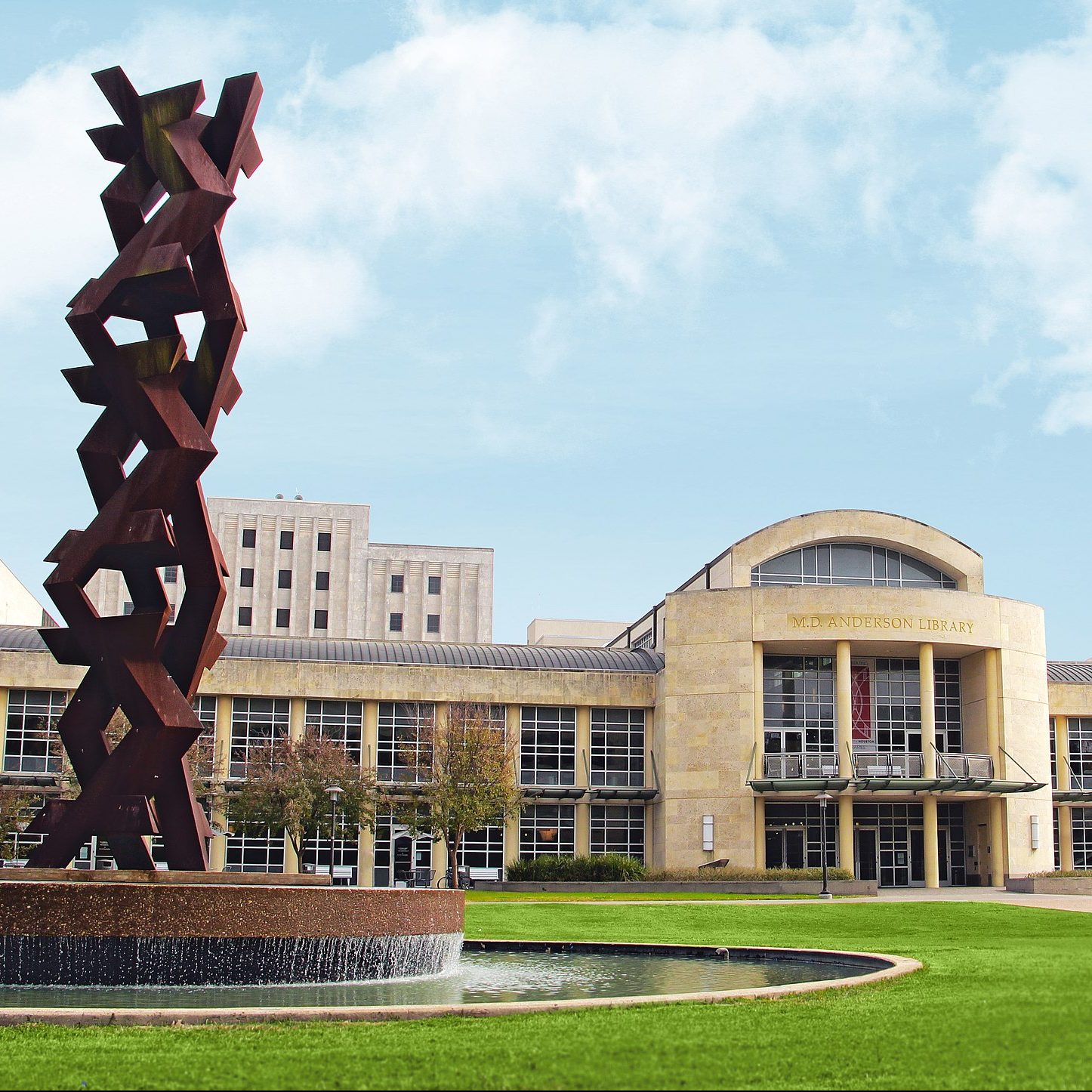 Photograph of University of Houston library and statue on lawn.