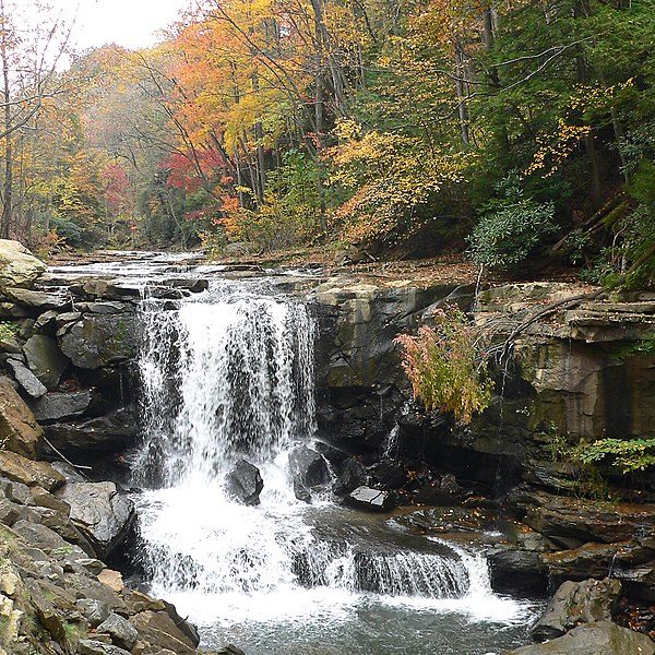 Photograph of small rocky appalachian waterfall in autumn wooded area.