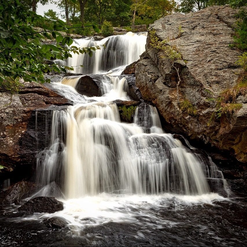 Photograph of multi tier waterfall in rocky, wooded area, Connecticut.