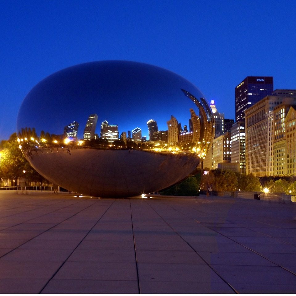 Photograph of “bean” reflective sculpture in Chicago park at night.