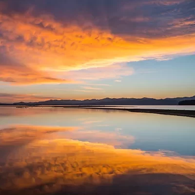 Sunrise over lake in Montana, clouds of yellow, orange, pink.