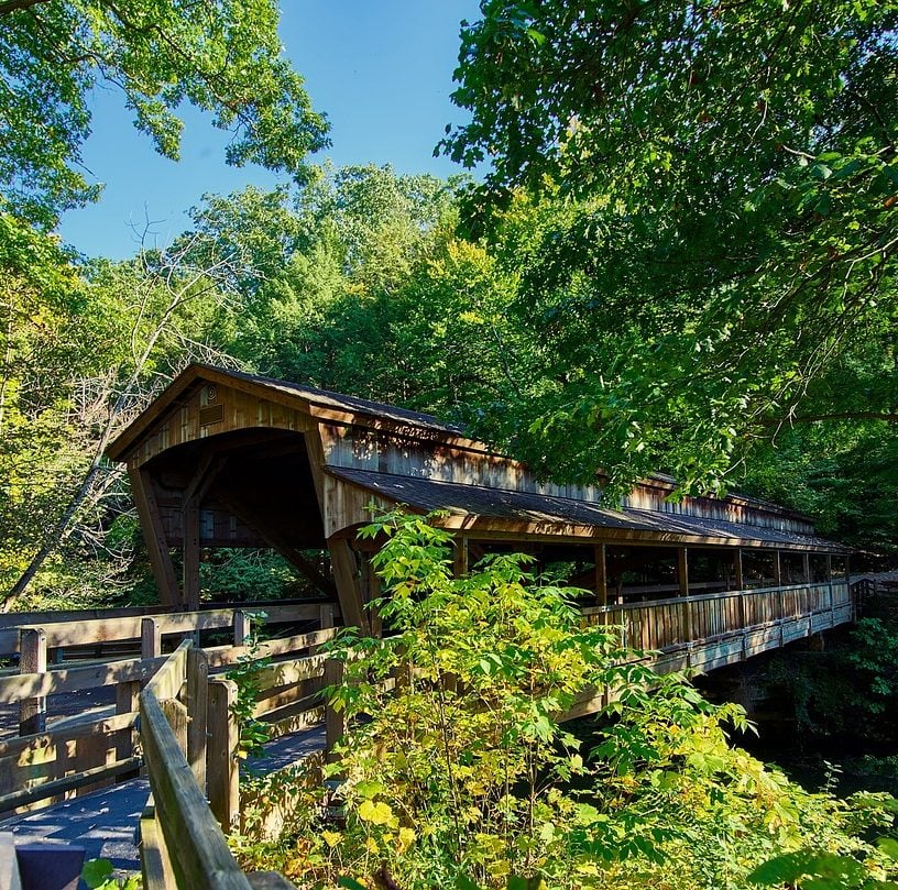 Photograph of a covered footbridge in wooded area in Ohio.
