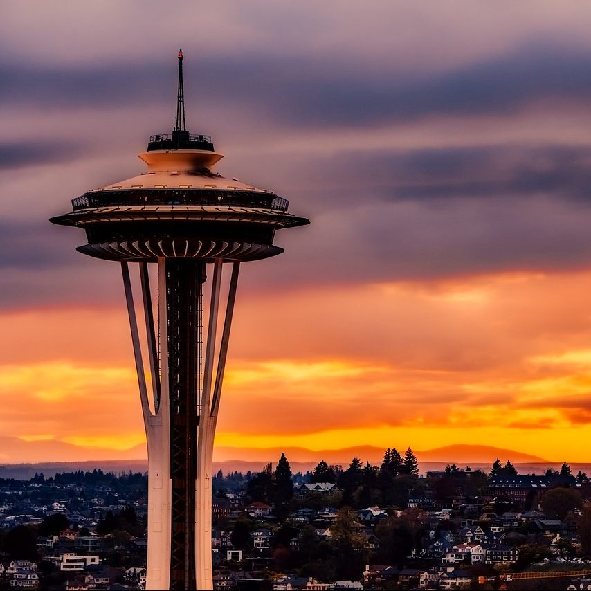 Photograph of Space Needle in Seattle, Washington, against orange sunset.