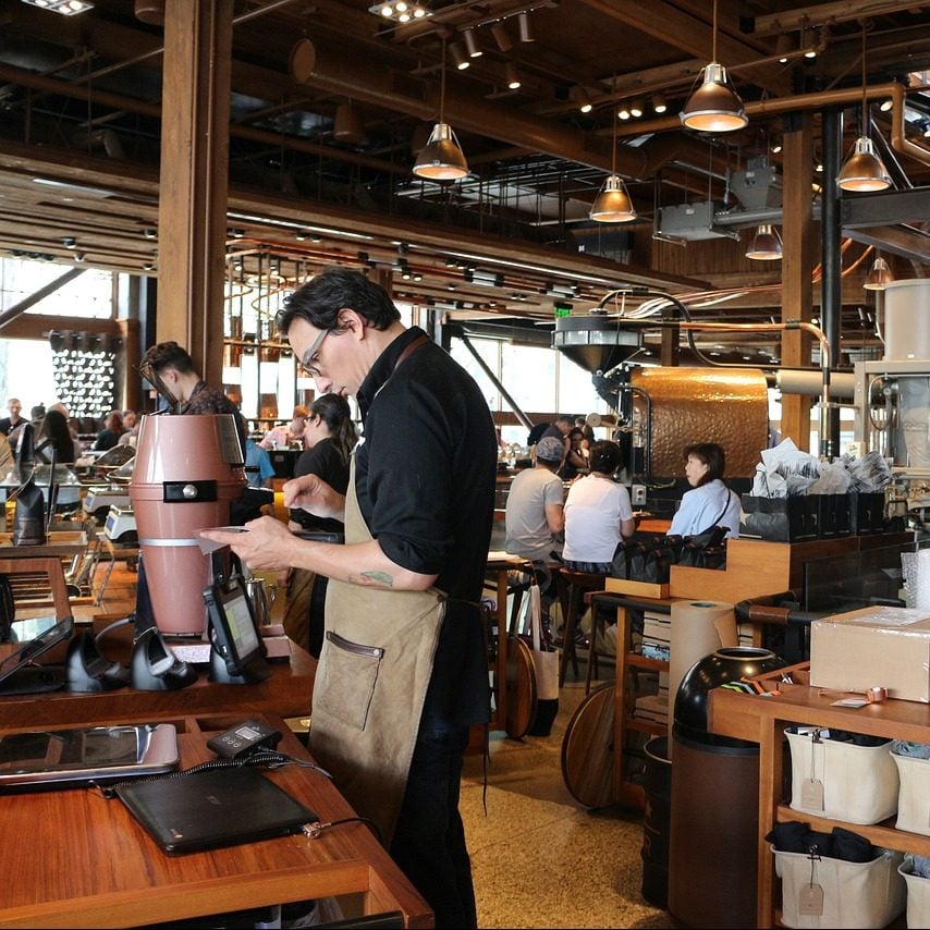 Photograph of a male barista preparing coffee in Seattle, Washington.